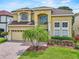 Beautiful yellow two-story home with brick driveway and landscaping at 5321 Los Palma Vista Dr, Orlando, FL 32837