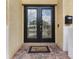Close-up of the beautiful double front doors with decorative glass and brick entryway at 5321 Los Palma Vista Dr, Orlando, FL 32837