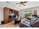 Comfortable living room featuring a large entertainment center and sliding glass doors to the patio at 5321 Los Palma Vista Dr, Orlando, FL 32837