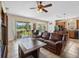Cozy living room with tile flooring, ceiling fan, and access to the outdoor patio at 5321 Los Palma Vista Dr, Orlando, FL 32837