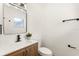 This half bath includes stylish fixtures, wood vanity and a sleek framed mirror at 620 Plum Ln, Altamonte Springs, FL 32701