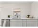 Bright kitchen features stainless steel dishwasher, white cabinets and stone countertops, with a modern black faucet at 620 Plum Ln, Altamonte Springs, FL 32701