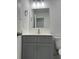 Stylish bathroom with gray vanity, modern fixtures, and ample lighting at 705 Wood Ln, Kissimmee, FL 34759