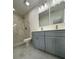 Modern bathroom with marble tile, gray vanity, and dual sinks at 705 Wood Ln, Kissimmee, FL 34759