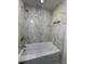 Bathroom featuring marble tile in shower and tub at 705 Wood Ln, Kissimmee, FL 34759