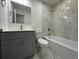Bathroom featuring marble tile, vanity with gray cabinets and a bathtub at 705 Wood Ln, Kissimmee, FL 34759