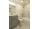 Bathroom featuring gray vanity, white marble-like tile shower, and modern fixtures at 705 Wood Ln, Kissimmee, FL 34759