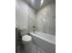 Bathroom featuring marble tile, vanity with gray cabinets and a bathtub at 705 Wood Ln, Kissimmee, FL 34759