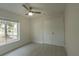 A light-filled bedroom includes a ceiling fan, a window with blinds, and closet for efficient storage at 705 Wood Ln, Kissimmee, FL 34759