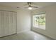 Bright bedroom features a ceiling fan, large window, and spacious closet for ample storage at 705 Wood Ln, Kissimmee, FL 34759