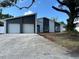 Charming home featuring a two-car garage, modern white exterior, and a spacious front yard at 705 Wood Ln, Kissimmee, FL 34759
