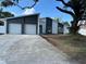 Charming home featuring a two-car garage, modern white exterior, and a spacious front yard at 705 Wood Ln, Kissimmee, FL 34759