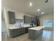 Bright kitchen with gray cabinets, stainless steel appliances, and a center island at 705 Wood Ln, Kissimmee, FL 34759