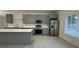 Modern kitchen featuring gray cabinets, stainless steel appliances, and a large island at 705 Wood Ln, Kissimmee, FL 34759