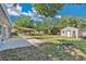 Spacious backyard featuring a large patio, shade sail, shed, and mature landscaping at 710 California Ave, St Cloud, FL 34769