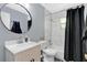 Updated bathroom with a modern vanity, stylish round mirror, and a shower-tub combo at 710 California Ave, St Cloud, FL 34769