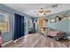 Bedroom with wood-look floors, blue walls, hunting decor, a ceiling fan, and sliding glass doors at 710 California Ave, St Cloud, FL 34769
