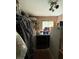 A laundry room with a washer and dryer, mini-fridge, overhead storage, and a window at 716 Grove Ave, Orlando, FL 32805