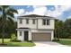 Two-story home with a neutral color scheme, front-facing garage, and well-maintained landscaping at 741 Lake Dell Ave, Dundee, FL 33838
