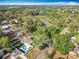 Aerial view of a fenced-in backyard featuring a pool, spa, well-kept lawn, and a nearby lake at 7823 Bell Blvd, Orlando, FL 32810