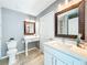 Bright bathroom featuring marble floors, a vanity with a white countertop, and a unique decorative mirror at 7823 Bell Blvd, Orlando, FL 32810