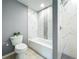 Modern bathroom featuring a white tub and a tiled shower with marble and black honeycomb tile accents at 7823 Bell Blvd, Orlando, FL 32810