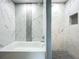 Modern bathroom featuring a white tub and a tiled shower with marble and black honeycomb tile accents at 7823 Bell Blvd, Orlando, FL 32810