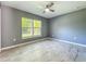 A light-filled bedroom with a large window, wood-look tile floors, and fresh gray paint at 7823 Bell Blvd, Orlando, FL 32810