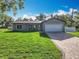 Charming home featuring a brick paver driveway, a well-manicured lawn, and fresh exterior paint at 7823 Bell Blvd, Orlando, FL 32810