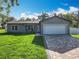 Charming single-story home features a well-manicured lawn and a spacious two-car garage at 7823 Bell Blvd, Orlando, FL 32810