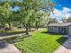 A charming single-Gathering home with a well-maintained lawn and sidewalk, under the shade of mature trees at 7823 Bell Blvd, Orlando, FL 32810