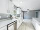 Modern kitchen with white cabinets, countertops, and stainless steel dishwasher at 7823 Bell Blvd, Orlando, FL 32810