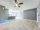 Open living room showcases modern tile floors, gray walls, and access to the kitchen and other areas at 7823 Bell Blvd, Orlando, FL 32810