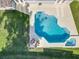 Aerial view of a private backyard oasis featuring a sparkling pool, relaxing spa, and comfortable lounge chairs at 7823 Bell Blvd, Orlando, FL 32810