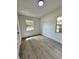 Bedroom with two windows allowing natural light and gray wood-look laminate flooring at 906 San Domingo Rd, Orlando, FL 32808