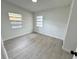 Well-lit bedroom showcasing wood-look flooring and two windows for natural light at 906 San Domingo Rd, Orlando, FL 32808