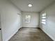 Bright bedroom featuring wood-look floors and ample natural light from two windows at 906 San Domingo Rd, Orlando, FL 32808