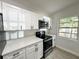Contemporary kitchen featuring white cabinets, black hardware, and stainless steel appliances at 906 San Domingo Rd, Orlando, FL 32808