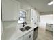 Updated kitchen area showcasing new sink fixtures, white cabinetry and matching quartz countertops at 906 San Domingo Rd, Orlando, FL 32808