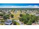 Aerial view of a residential neighborhood with a green field, trees, paved roads and a blue playground area at 923 Gascony Ct, Kissimmee, FL 34759
