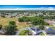 Wide aerial view of residential neighborhood with a green field, lush trees, paved roads and blue skies at 923 Gascony Ct, Kissimmee, FL 34759