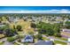 Aerial view of residential neighborhood with a green field, lush trees, paved roads, and blue skies at 923 Gascony Ct, Kissimmee, FL 34759