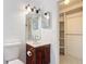 Bathroom featuring a vanity with a dark wood cabinet, a mirror, and a walk-in closet at 923 Gascony Ct, Kissimmee, FL 34759