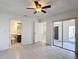 Bright bedroom with tiled floors, ceiling fan, and access to a bathroom at 923 Gascony Ct, Kissimmee, FL 34759