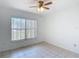 Bright bedroom featuring neutral tile flooring, a ceiling fan, and a window allowing natural light at 923 Gascony Ct, Kissimmee, FL 34759