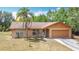 Charming single-story home featuring a palm tree, a two-car garage, and manicured landscaping at 923 Gascony Ct, Kissimmee, FL 34759