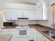 Well-lit kitchen with white cabinetry and standard appliances at 923 Gascony Ct, Kissimmee, FL 34759