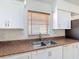 Bright kitchen featuring white cabinets, stainless steel sink, and neutral countertops at 923 Gascony Ct, Kissimmee, FL 34759