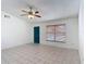 Well-lit living room with tile floors, a ceiling fan, and a contrasting blue front door at 923 Gascony Ct, Kissimmee, FL 34759