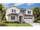 Charming two-story home featuring stone accents, a two-car garage, and a well-manicured lawn at 1058 Cloud Ridge Ct, Mount Dora, FL 32757